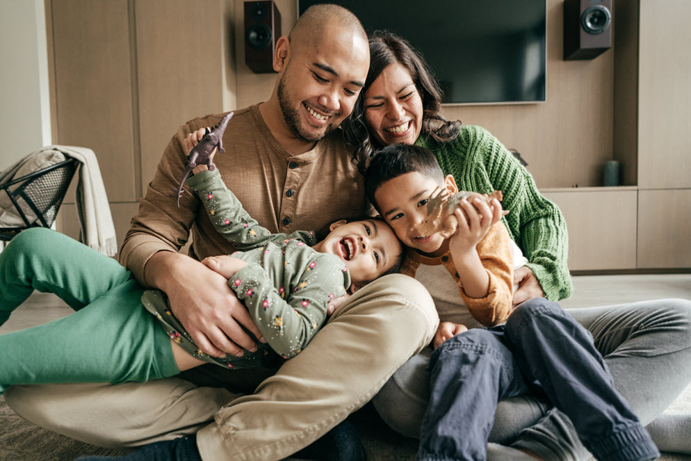 young family laughing together on couch